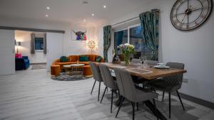 皮特洛赫里Heather House , luxury holiday house in Pitlochry的用餐室以及带桌椅的起居室。