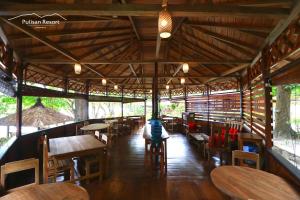 RinondoranPulisan Resort的餐厅设有木桌和木椅