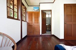 秾莎Nongsa Village Peaceful Villa in private beach Resort的一间铺有木地板的走廊和一扇门