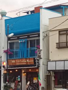 伊豆Ryokan La Luna - Vacation STAY 22160v的蓝色的建筑,在街上设有阳台