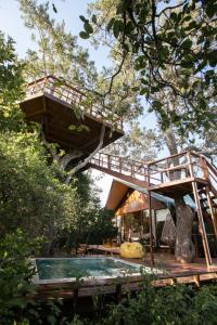 雅拉Tribe Yala - Luxury Camping的一座树屋,里面设有游泳池和一座桥梁