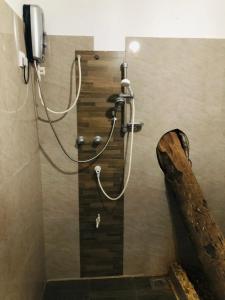 米瑞莎Hotel La Felicita的带淋浴的浴室(带木墙)