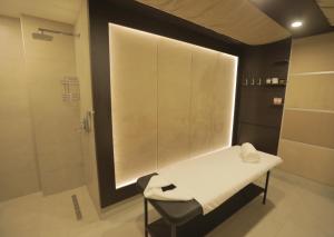 埃里温Dave Hotel Yerevan的浴室配有淋浴和带毛巾的长凳
