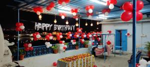 布什格尔Hotel Bharatpur Palace的一间房间,装有红色和白色的气球,并有一个快乐的生日标志