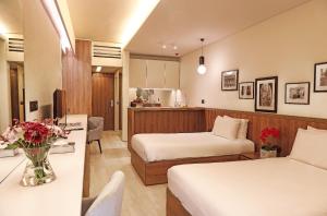 Bayt al KūkūLe Pave Residences的酒店客房,设有两张床和一张鲜花桌。
