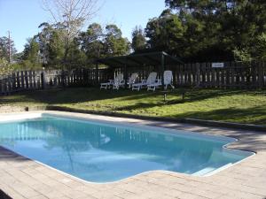 NicholsonLakes Bushland Caravan & Lifestyle Park的一个带椅子和围栏的庭院内的游泳池