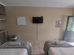 波罗瓜尼DeLutz Overnight Accommodation Room 2的客房设有两张床和一台墙上的电视。