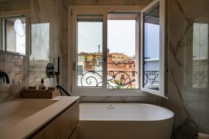 博洛尼亚PANORAMA APARTMENT的带浴缸的浴室和窗户。