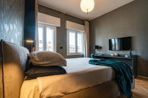 博洛尼亚PANORAMA APARTMENT的一间卧室配有带枕头的床铺和电视。