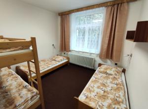 Rudná pod PradědemPenzion KUDLIK的客房设有三张双层床和一扇窗户。