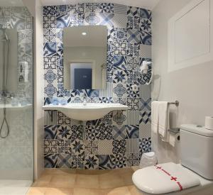 克罗姆港克罗姆港HPC旅馆的浴室设有水槽和蓝色及白色瓷砖