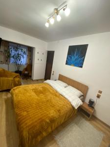 布拉索夫Casa Felice的一间卧室配有一张带黄色毯子的大床