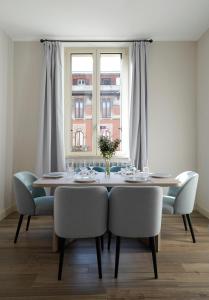 米兰numa I Loreto Apartments的餐桌、椅子和窗户