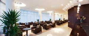 萨格勒布阿里斯托斯酒店的一间设有桌椅和植物的等候室