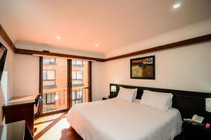 波哥大普勒尼图德公寓旅行者酒店的一间卧室设有一张床和一个大窗户