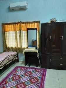 甲抛峇底Homestay Zulaika Kota Aur的一间卧室配有一张床、梳妆台和镜子