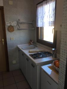 乌马格Apartmani Mirjana Umag的厨房配有炉灶、水槽和窗户。