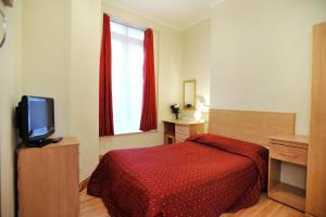 伦敦榆木酒店的一间卧室配有红色的床和电视