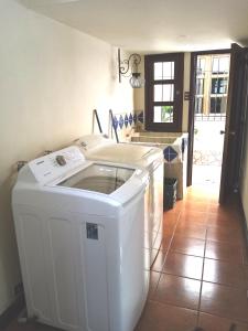 危地马拉安地瓜Bella Casa en Antigua Guatemala的带厨房的客房内的洗衣机和烘干机