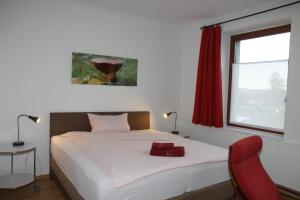 瓦尔堡FAMOS Schlafen的一间卧室配有一张床和一张红色椅子