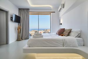 阿诺梅拉Teal Rock Mykonos的白色的卧室设有一张大床和一个大窗户