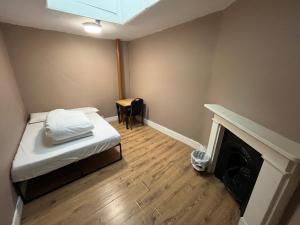 伦敦伊丽莎白女王旅舍的一间小房间,配有一张床和一个壁炉