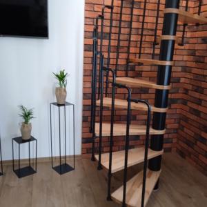 克罗奇琴科Apartament w Pieninach的螺旋楼梯,旁边是砖墙,有两边桌子