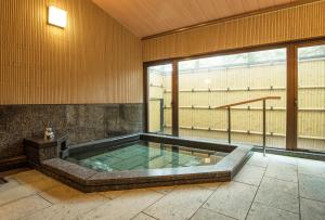 高野山高野山 宿坊 普門院 -Koyasan Shukubo Fumonin-的带大窗户的客房内的热水浴池