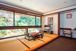 高野山高野山 宿坊 普門院 -Koyasan Shukubo Fumonin-的客厅设有桌子和大窗户