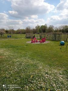 OisselBungalow la Bohémienne的草地上带红色椅子的公园