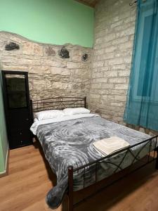 利马索尔Zouglas App Guesthouse的石墙房间内的一张床位