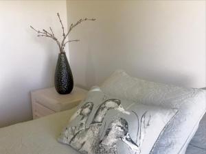 坎布里奇Maungatautari Outlook Cambridge的卧室配有枕头和床边花瓶