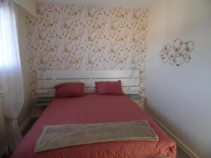 圣让-德蒙RESIDENCE LES BARGES的一间卧室配有红色床单和红色枕头。