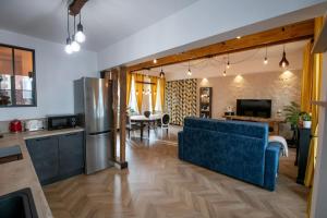 尚蒂伊La Suite de Chantilly - Appartement de 80m2 avec Jacuzzi privé !的一间带蓝色沙发的客厅和一间厨房