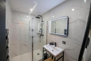 尚蒂伊La Suite de Chantilly - Appartement de 80m2 avec Jacuzzi privé !的白色的浴室设有水槽和淋浴。