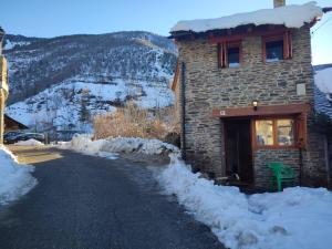 Esterri de CardósCasa Pirineu的路边有雪的石头建筑