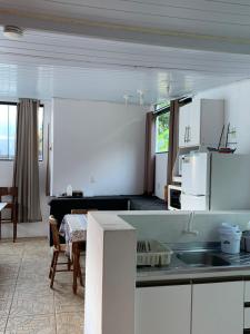 弗洛里亚诺波利斯Casa Ribeirao da Ilha的一间厨房,内设白色橱柜和一张桌子