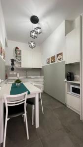 佛罗伦萨GUEST HOUSE KINGA CAVOUR的厨房配有白色的桌子和白色的橱柜。
