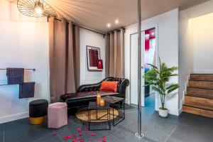 谢西LoveSparadise - Suite L'élixir的客厅配有黑色真皮沙发和桌子