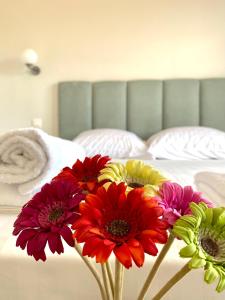 埃泽萨Eternal Suites Edessa的睡在床上的花瓶里的一束鲜花