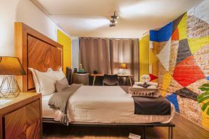 墨西哥城Nomadier Experience Mexico City Condesa的酒店客房设有床和色彩缤纷的墙壁。