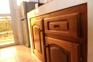 雅温得Le Mas Provençal - Appartements的厨房配有木制橱柜和冰箱。
