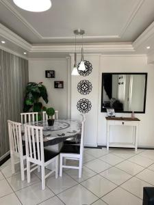 巴拉奈里奥-坎布里乌Apartamento Praia Central的一间配备有白色桌椅的用餐室