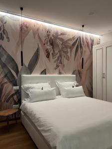 埃朗根The Kepos Hotel Erlangen的卧室配有一张白色大床和花卉墙