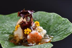 龟冈京汤之花翠泉日式旅馆的绿叶上的甲虫,上面有鲜花