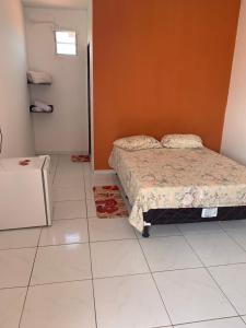 加利纽斯Chalé Recanto do Paraíso的卧室配有床,铺有白色瓷砖地板。