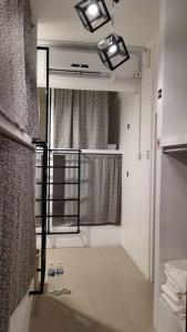 古晋Sunset Homestay - Backpacker Hostel Self Checkin的带淋浴的白色浴室和窗户。