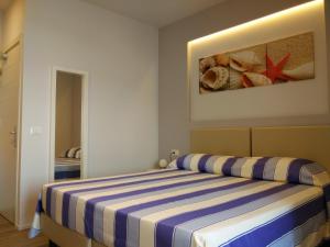 阿祖罗港拉普罗多酒店的一间卧室配有一张蓝色和白色条纹的床