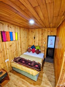 努沃勒埃利耶皮金斯奈斯特酒店的木制客房内的一间卧室,配有一张床