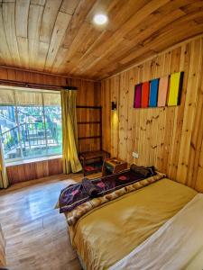 努沃勒埃利耶皮金斯奈斯特酒店的卧室配有一张床铺,位于带木墙的房间内